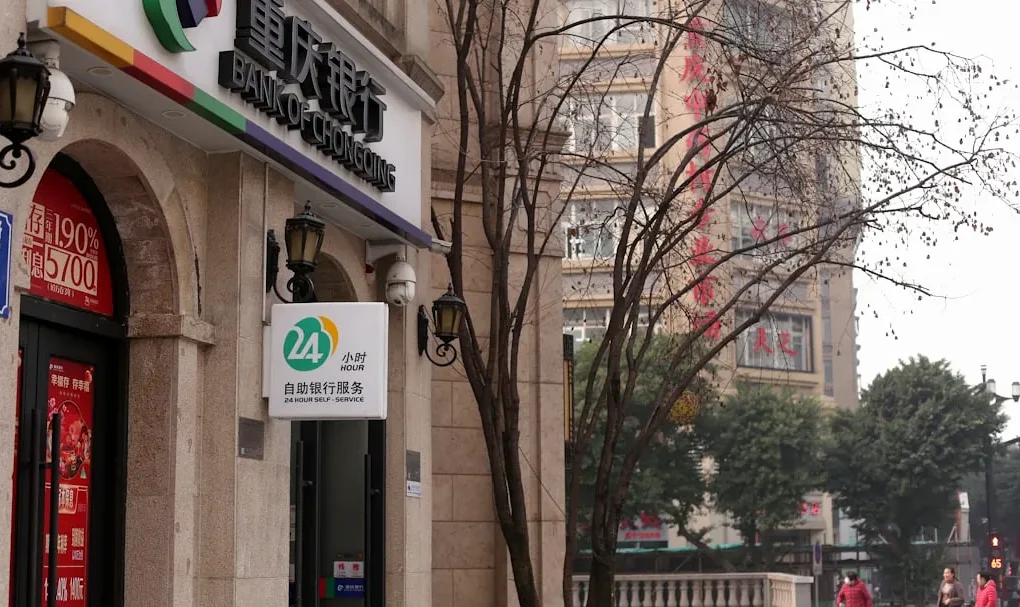 A bank building with signage and a bare tree.