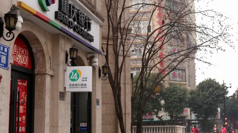 A bank building with signage and a bare tree.