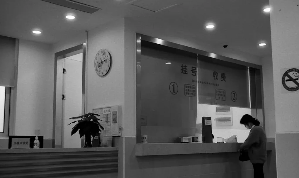 a black and white photo of a woman standing in front of a counter