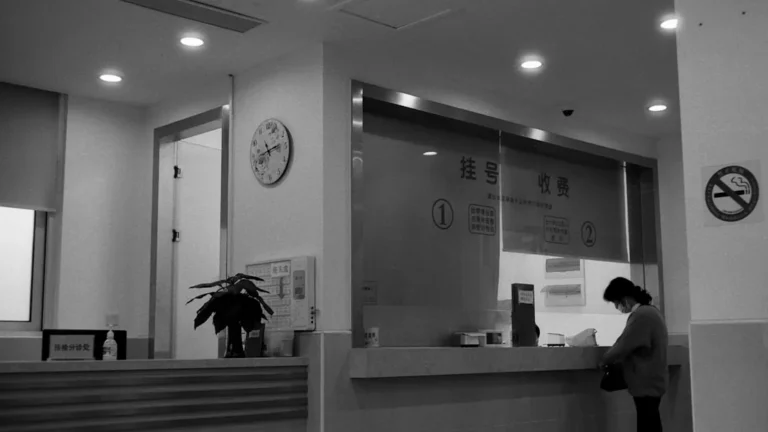 a black and white photo of a woman standing in front of a counter