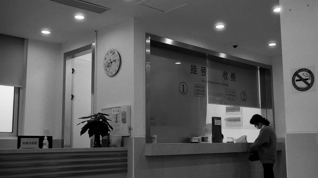 a black and white photo of a woman standing in front of a counter