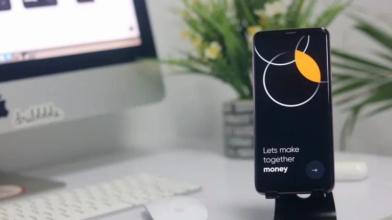 a cell phone sitting on top of a desk next to a computer