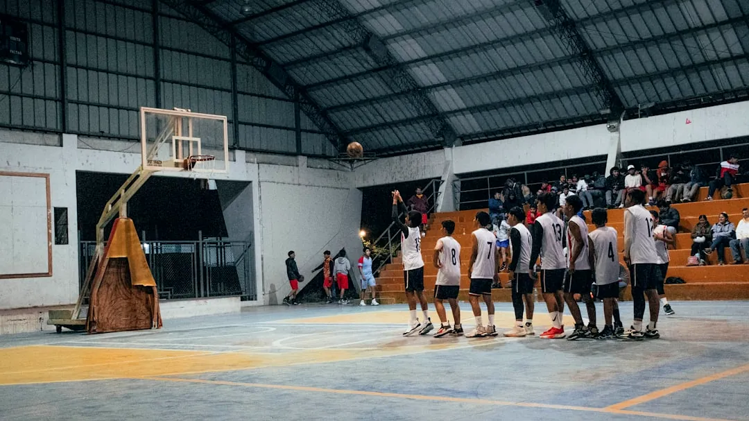 A group of men standing around a basketball court