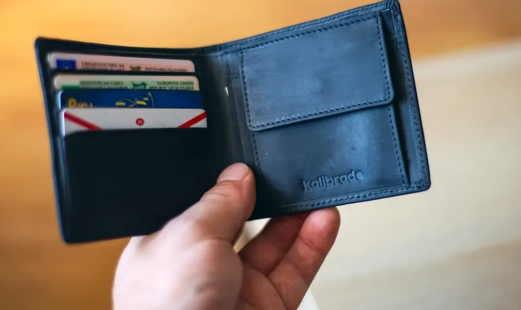 black leather bifold wallet on persons hand