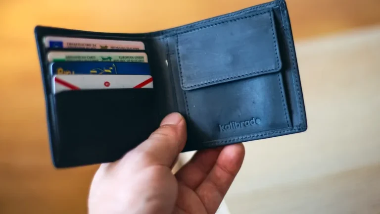 black leather bifold wallet on persons hand