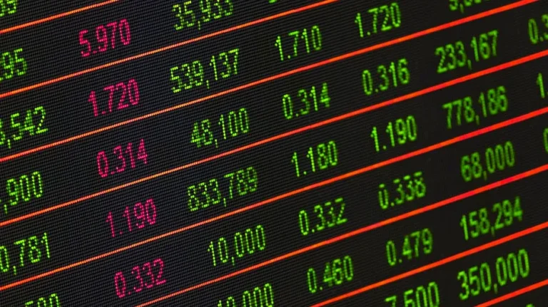 Close-up of a digital stock market data display showing colorful financial numbers and trends.