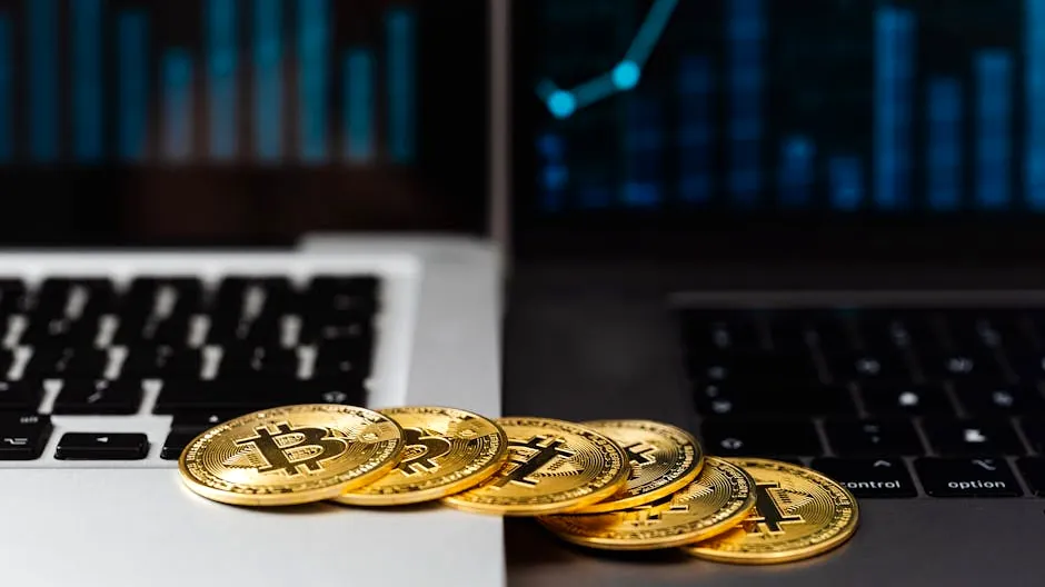 Gold bitcoins placed on laptop keyboards with digital financial graphs in the background.