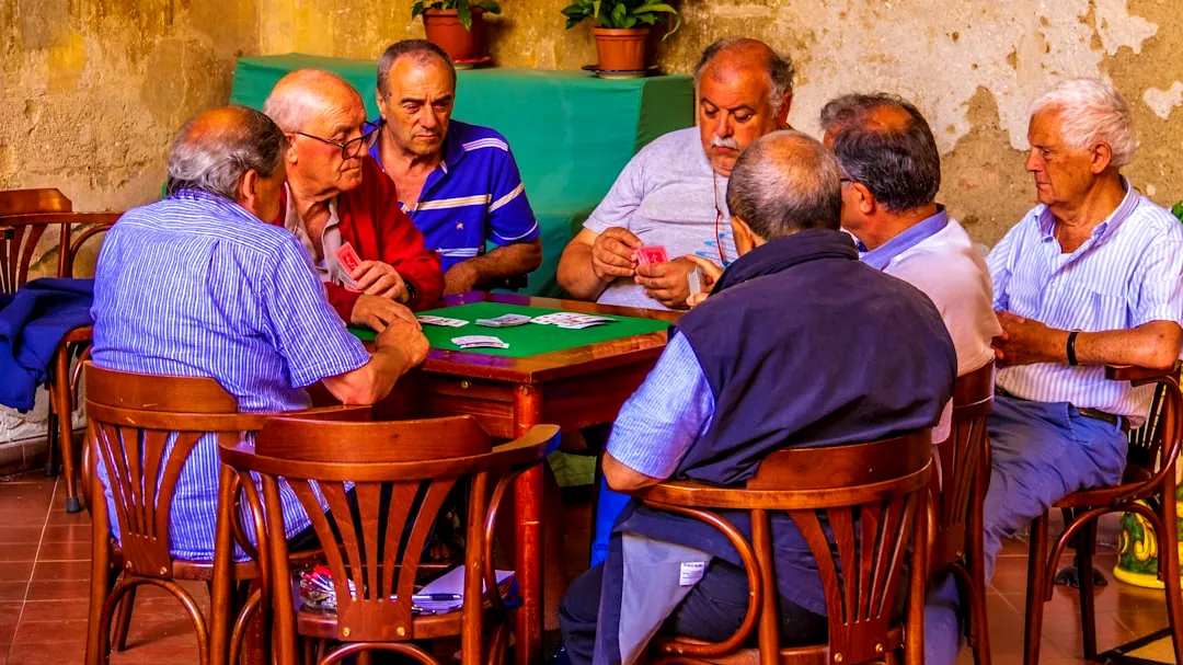 group of men sitting on chair in front of table