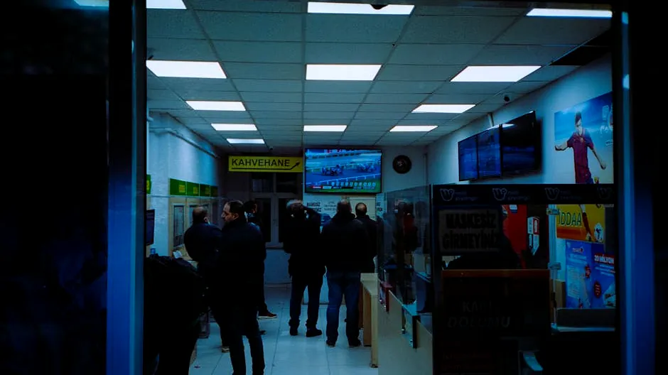 Interior of a Turkish betting cafe with people watching sports and placing bets.