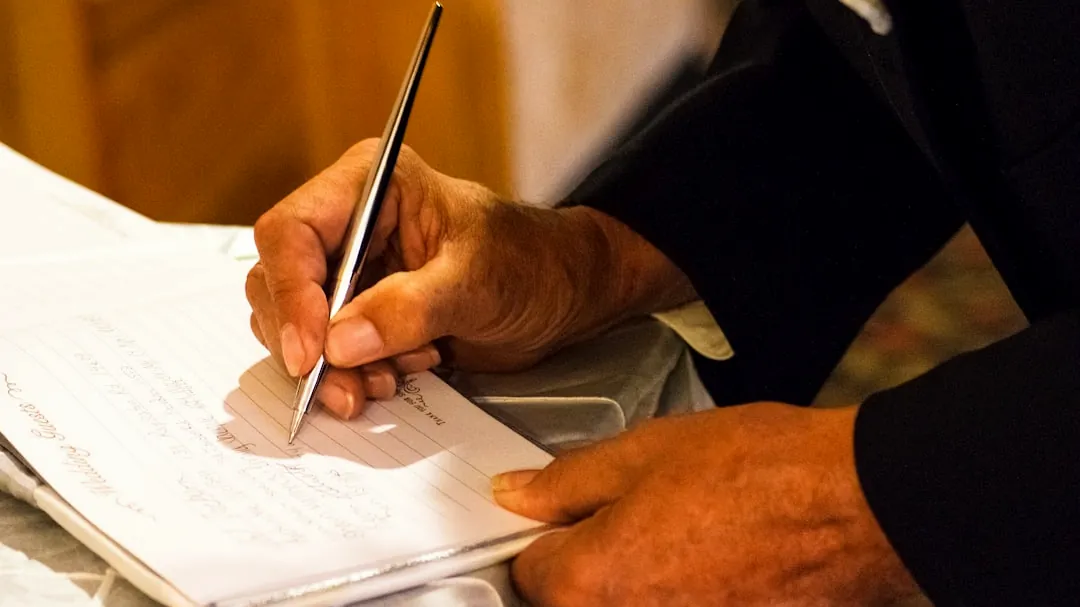 person writing on notebook