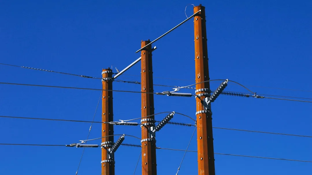 Wooden power poles against a clear blue sky