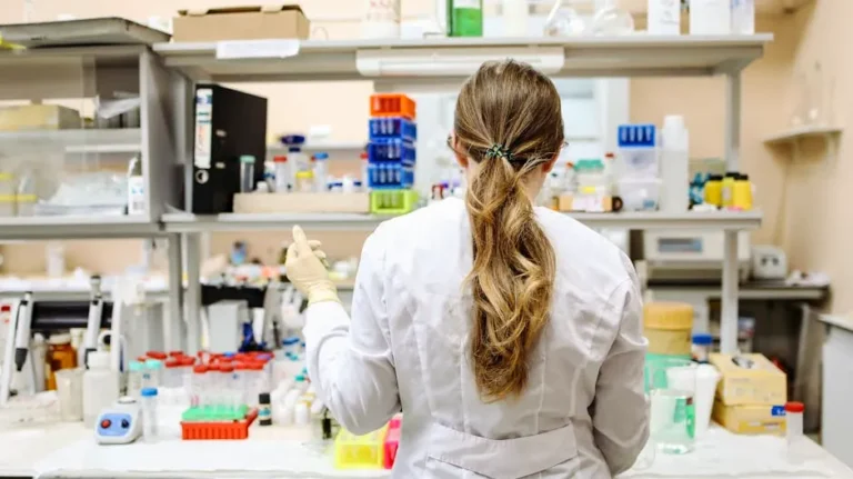 A female scientist conducting research in a well-equipped laboratory, focusing on chemical analysis.