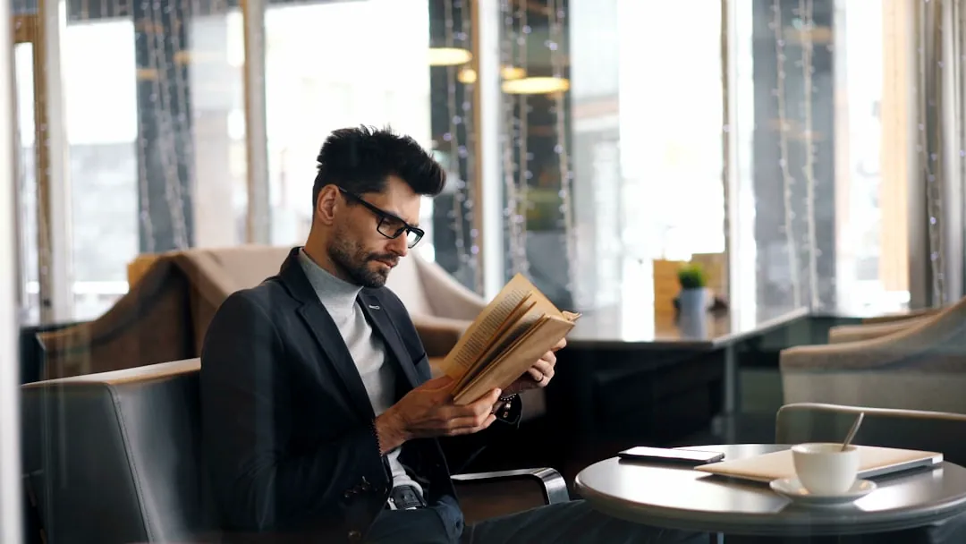 a man sitting at a table reading a book
