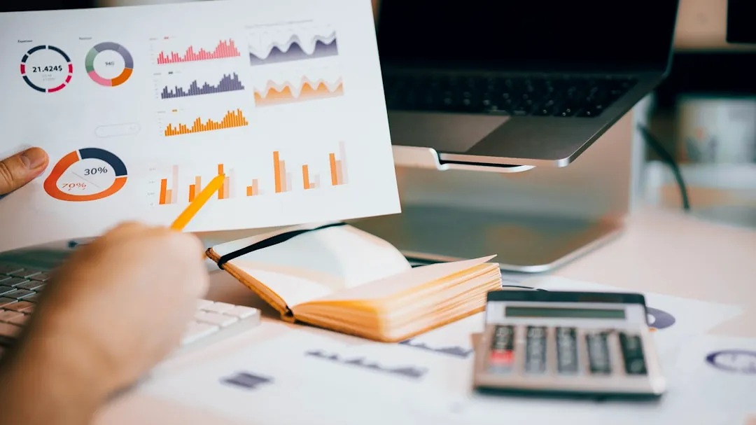 a person holding a piece of paper over a laptop