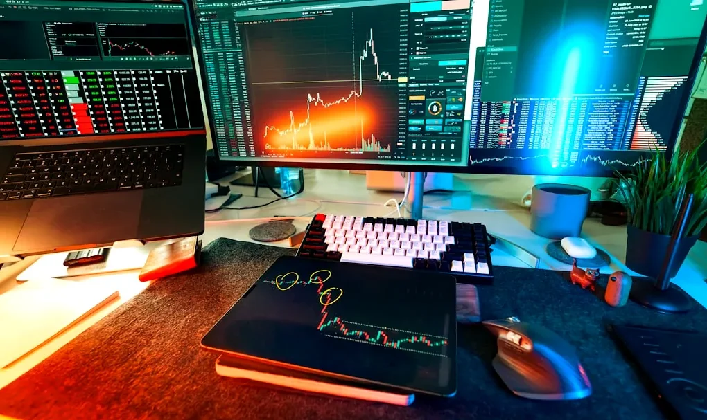 A trader's desk is lit up with charts.