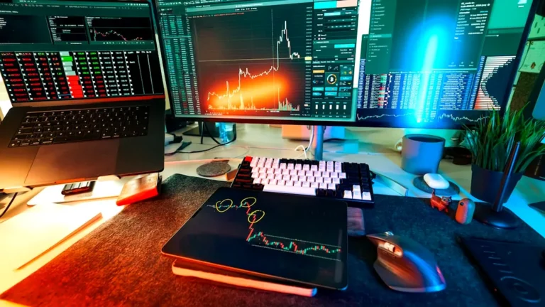 A trader's desk is lit up with charts.