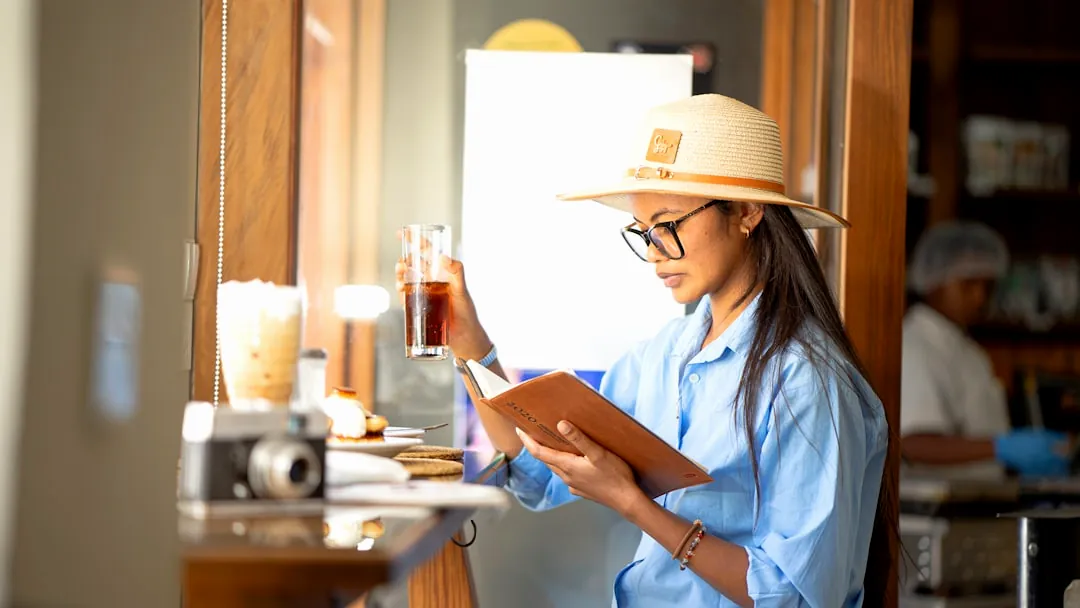 A woman wearing a hat and reading a book