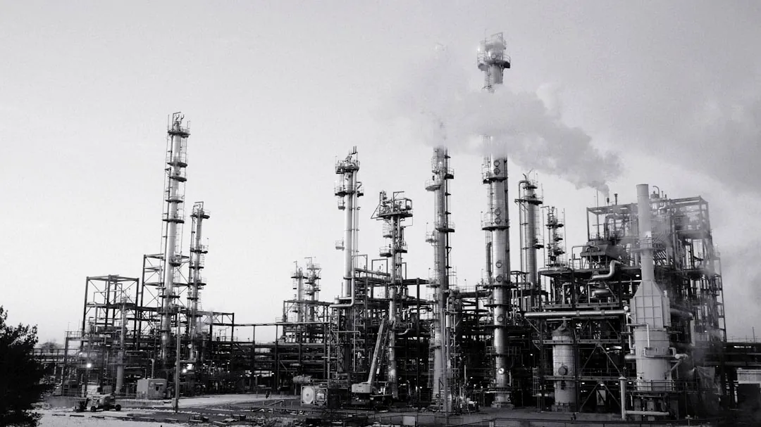 Industrial refinery with smoking stacks under a cloudy sky