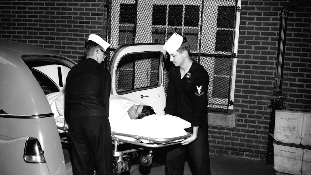 Two medics load patient onto stretcher from ambulance.