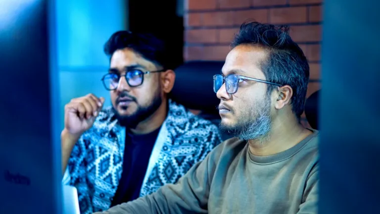 Two men looking intently at a computer screen.